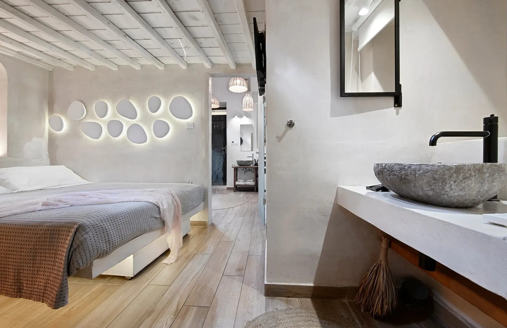 Maisonette bedroom next to a stone basin and vanity