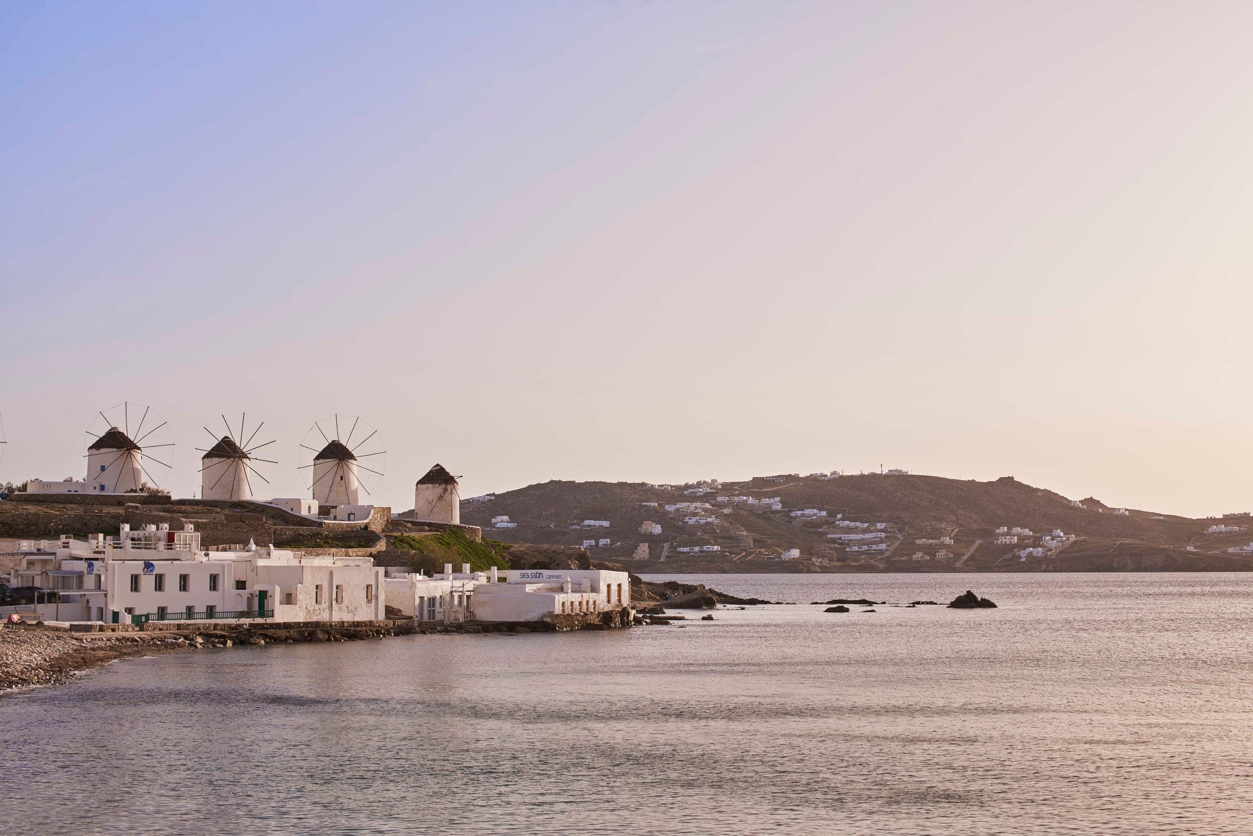The windmills above Mykonos Town seen across the water