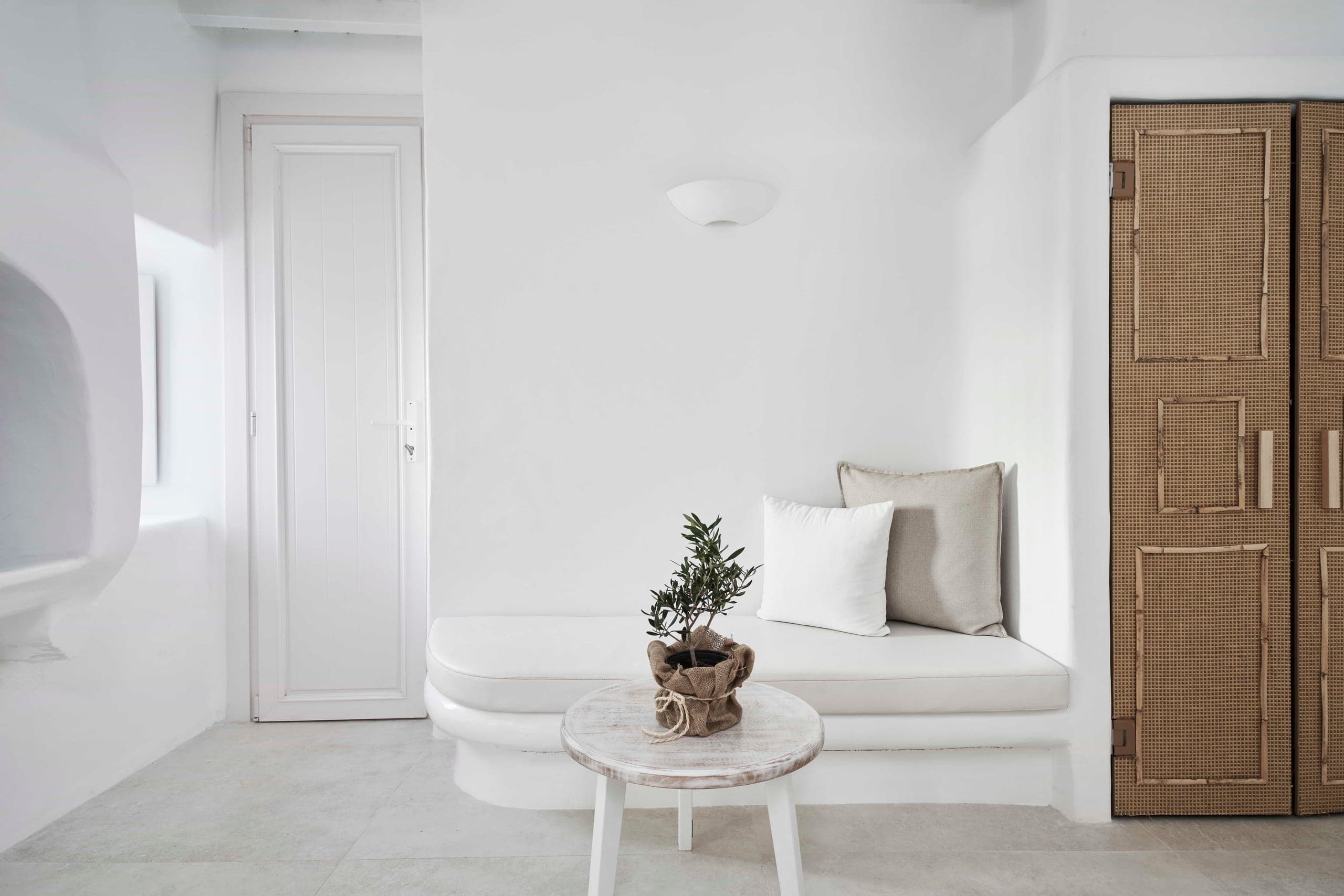 Built-in sofa and side table beside wooden doors