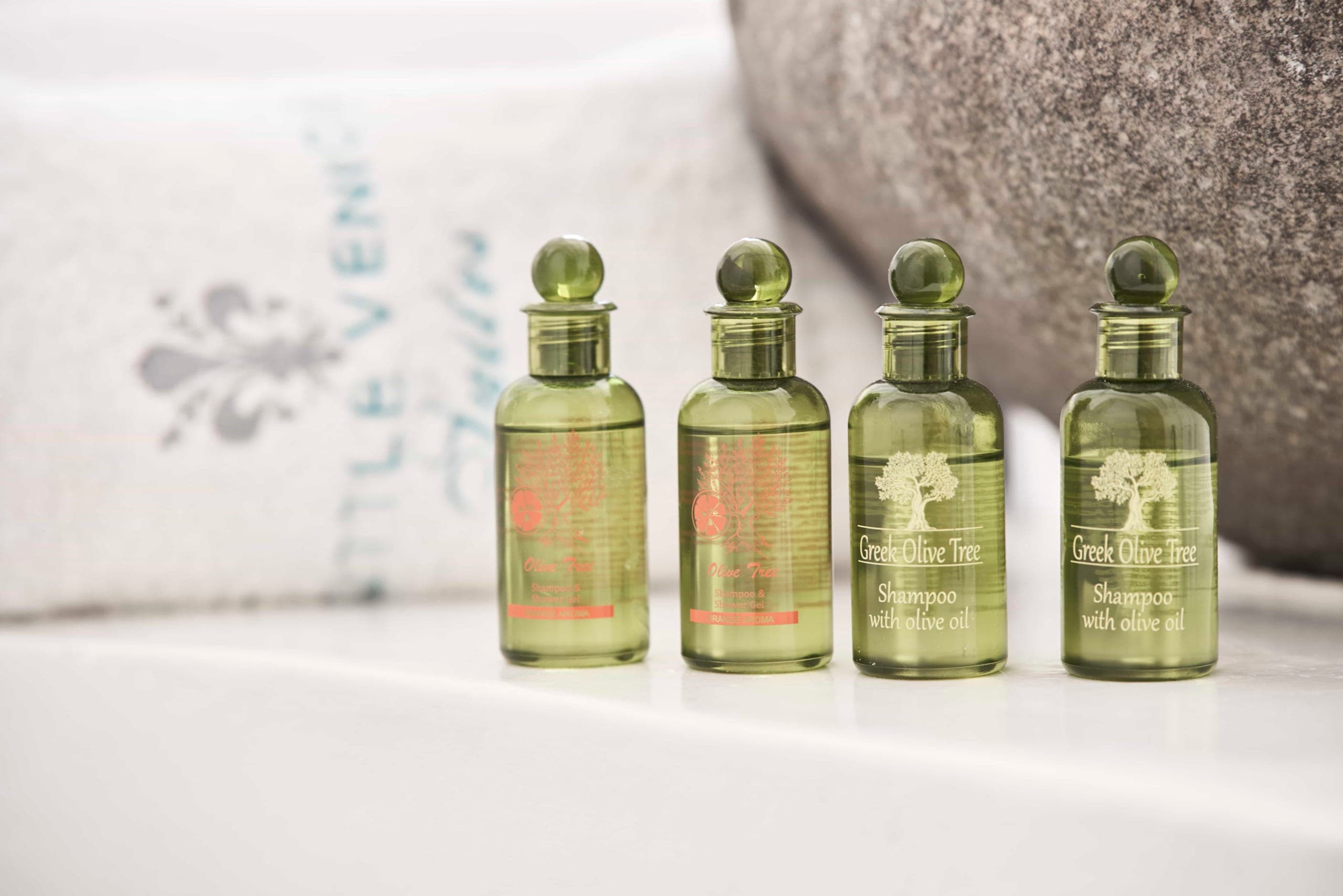 Olive-oil toiletries lined up on a white shelf