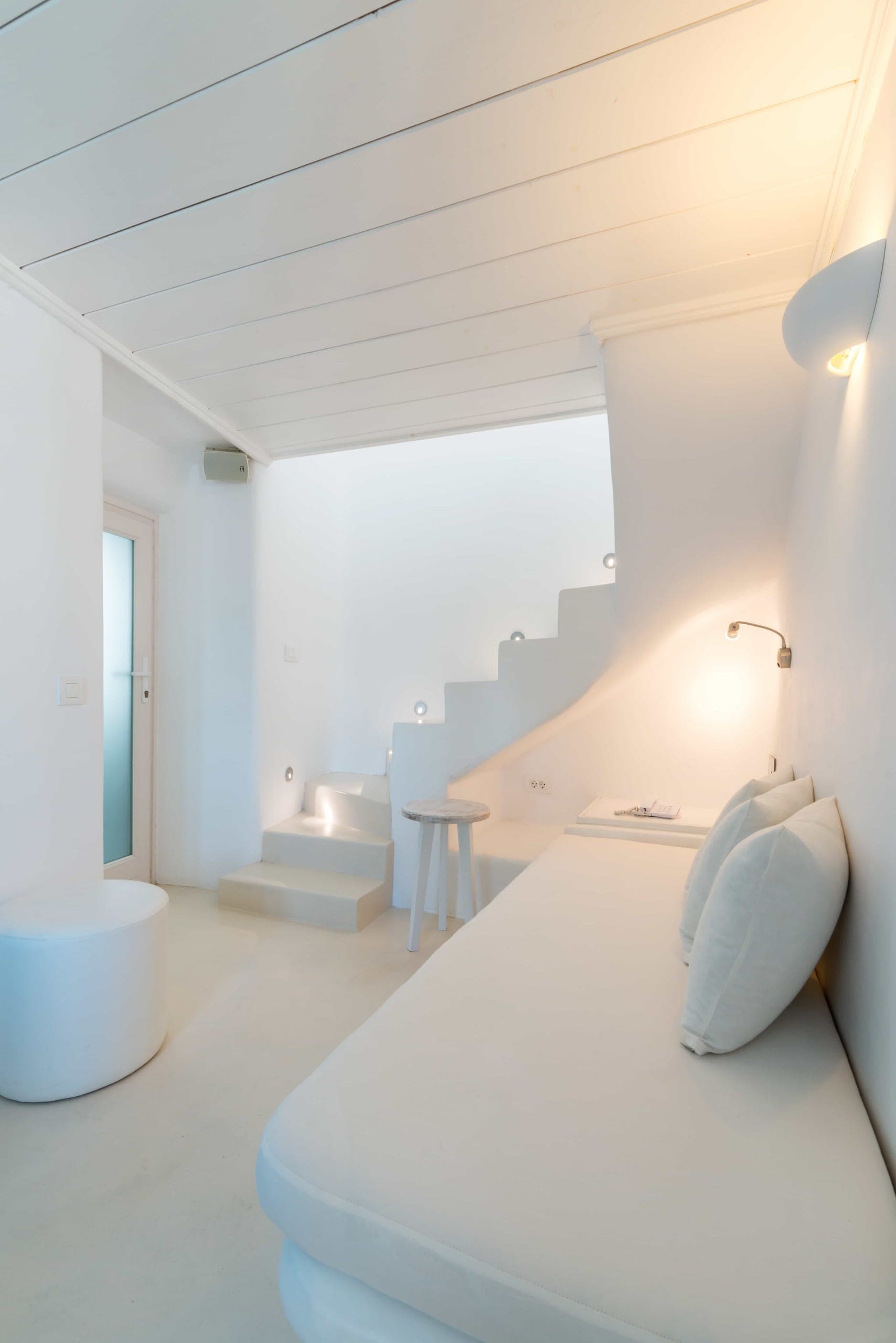 Split-level suite with built-in sofa and steps up to the bedroom