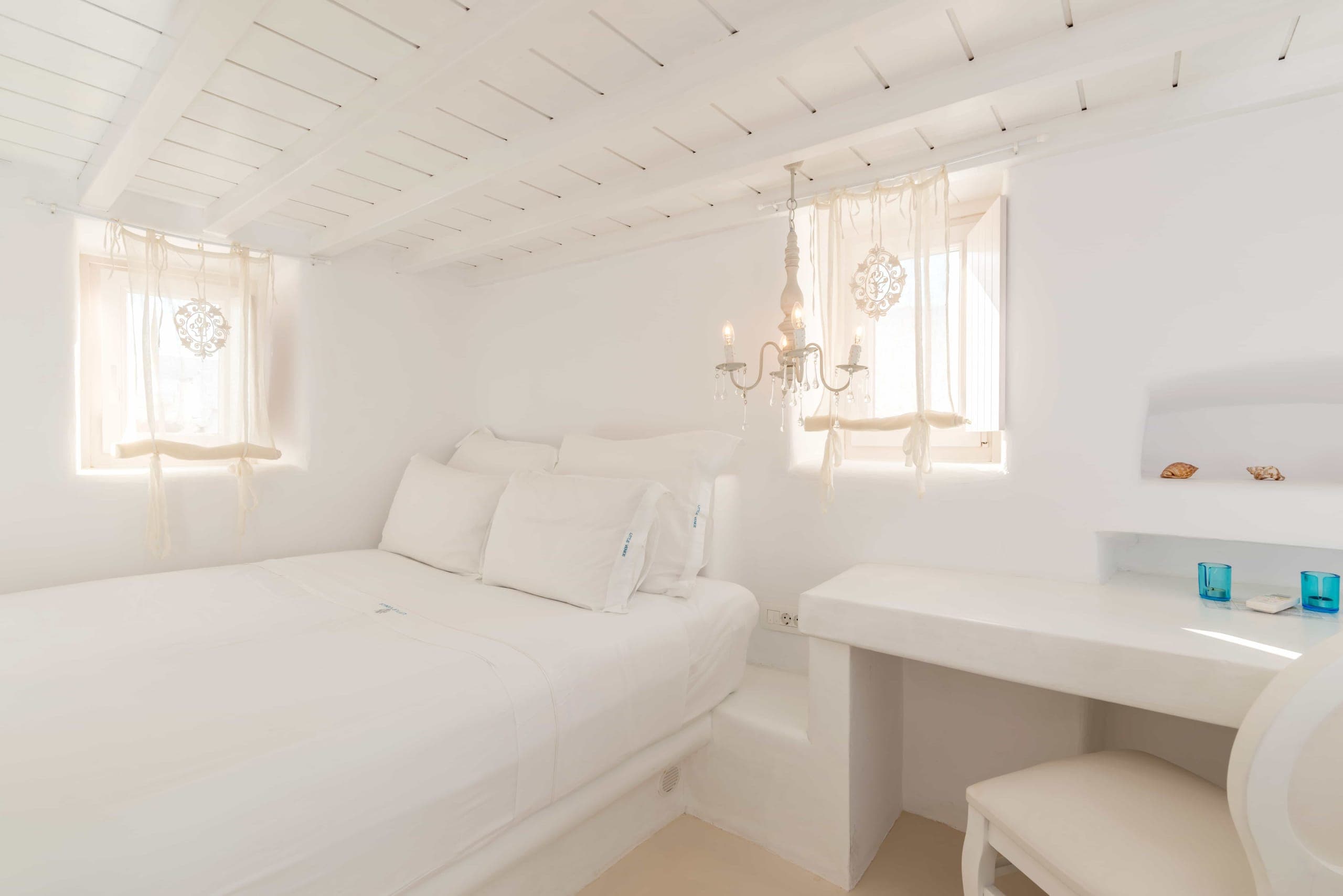 White bedroom with double bed and built-in desk