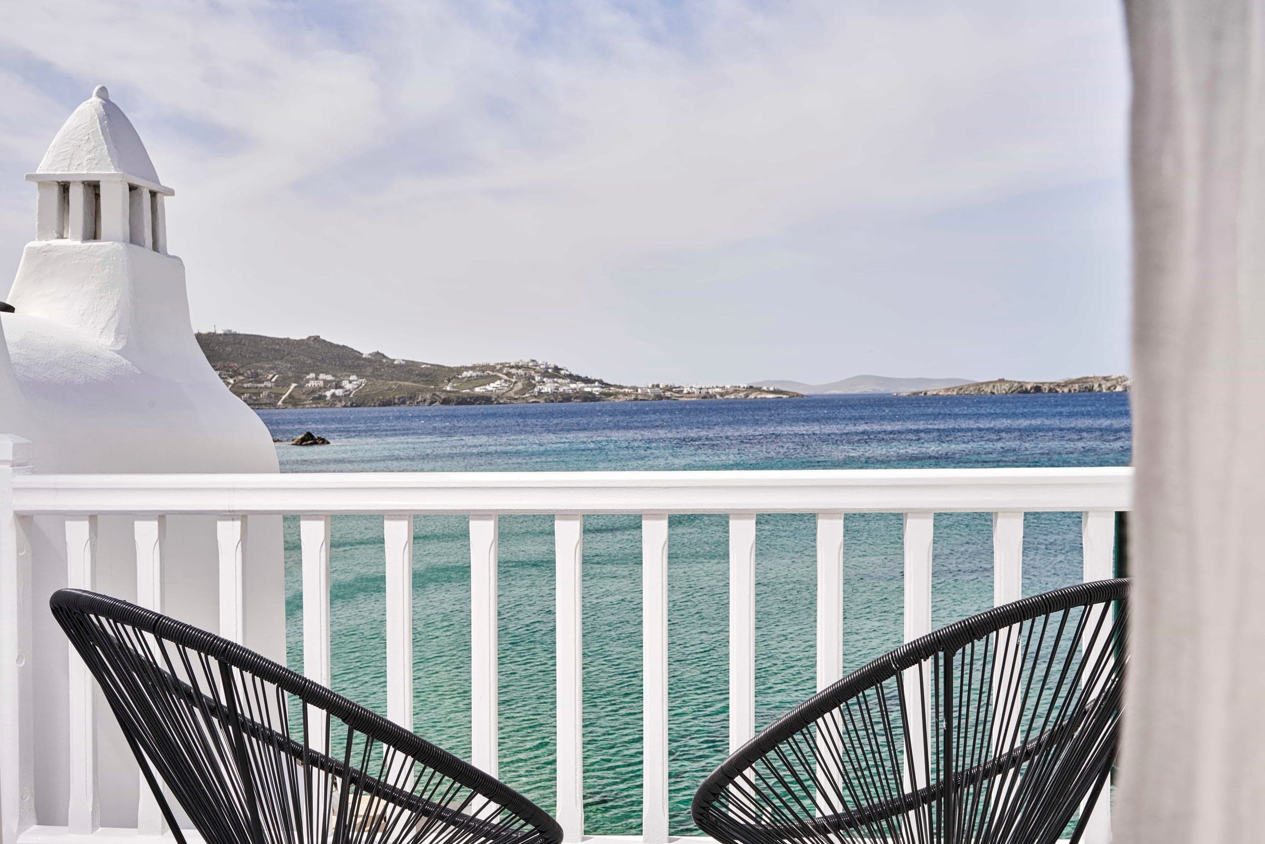 Balcony with two chairs overlooking the Aegean and Mykonos Town