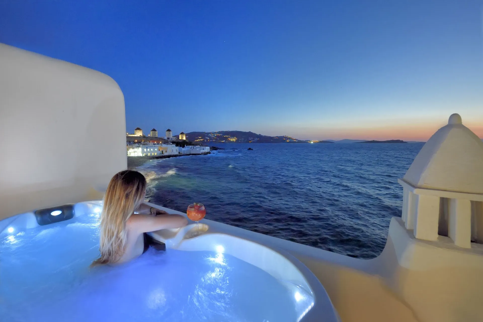 Outdoor Jacuzzi at dusk facing the sea and the windmills