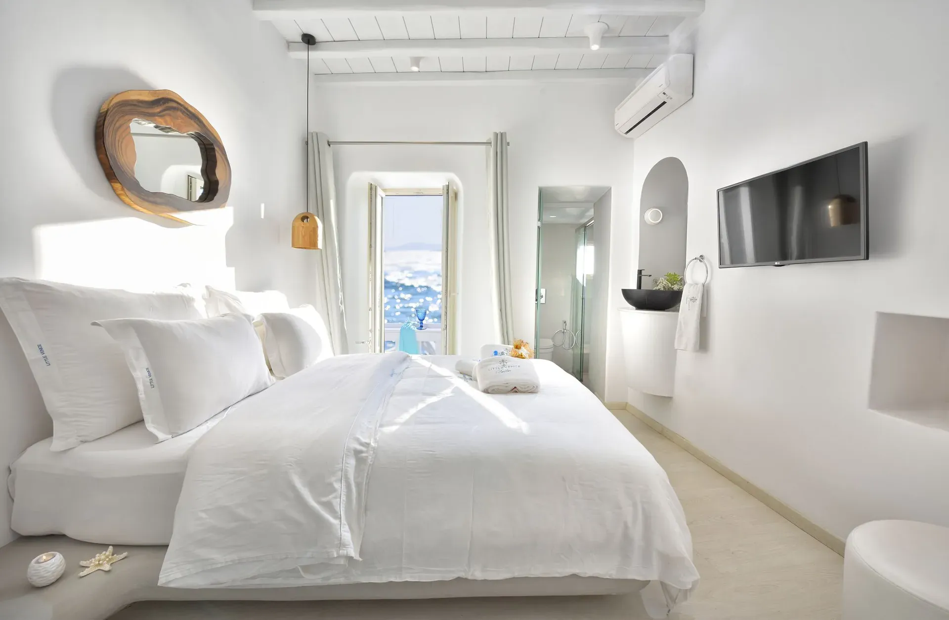 Large double bed with a sea view through the balcony door