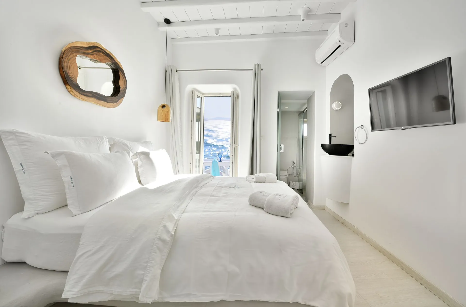 Bedroom with large double bed, wall TV and balcony door