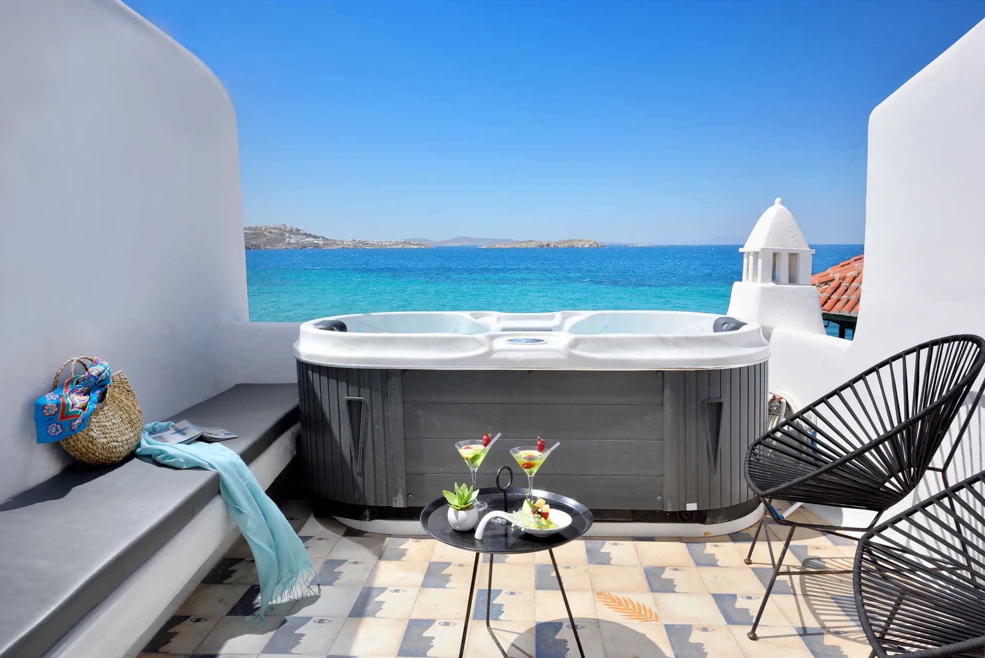 Outdoor Jacuzzi and lounge chairs on a sea-view terrace